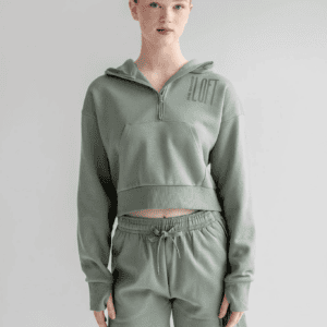 A model wearing the Dusty Green Essentials Cropped Fleece Quarter-Zip, showcasing its relaxed cropped fit, quarter-zip front, and customizable design for dance studios.