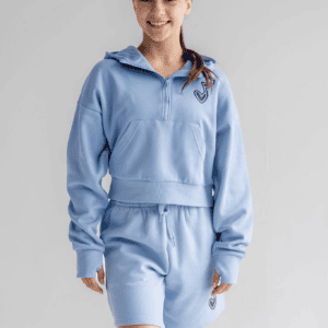 Dancer wearing Limelight Teamwear's relaxed unisex fit 7" custom fleece shorts featuring side pockets and a custom studio logo print on the left thigh.